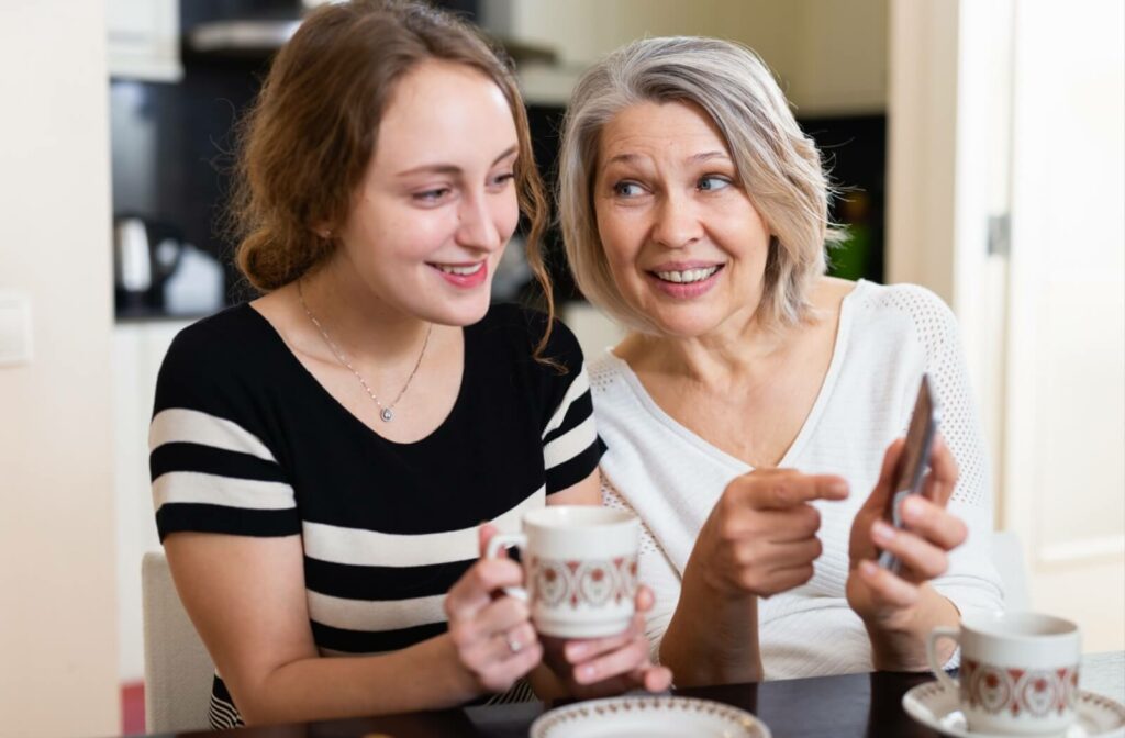 An older adult woman with dementia asking for assistance from a young woman to use her phone and answer a call