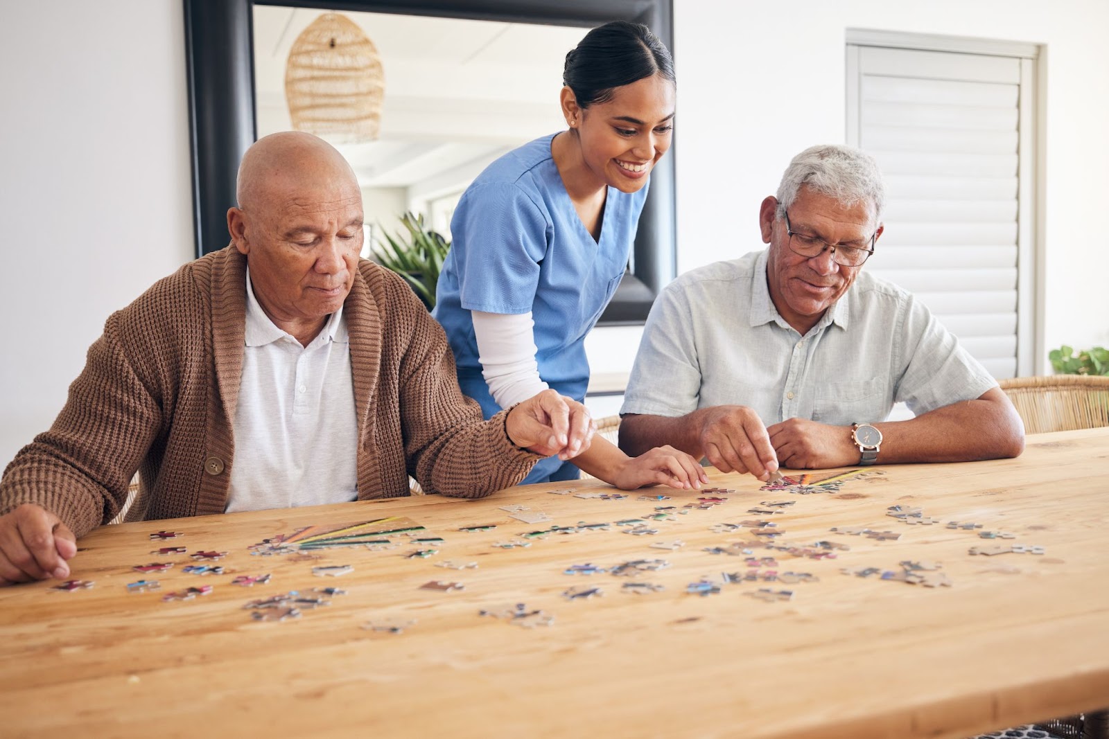 A nurse smiling while she works on a puzzle with 2 older men sitting at a table