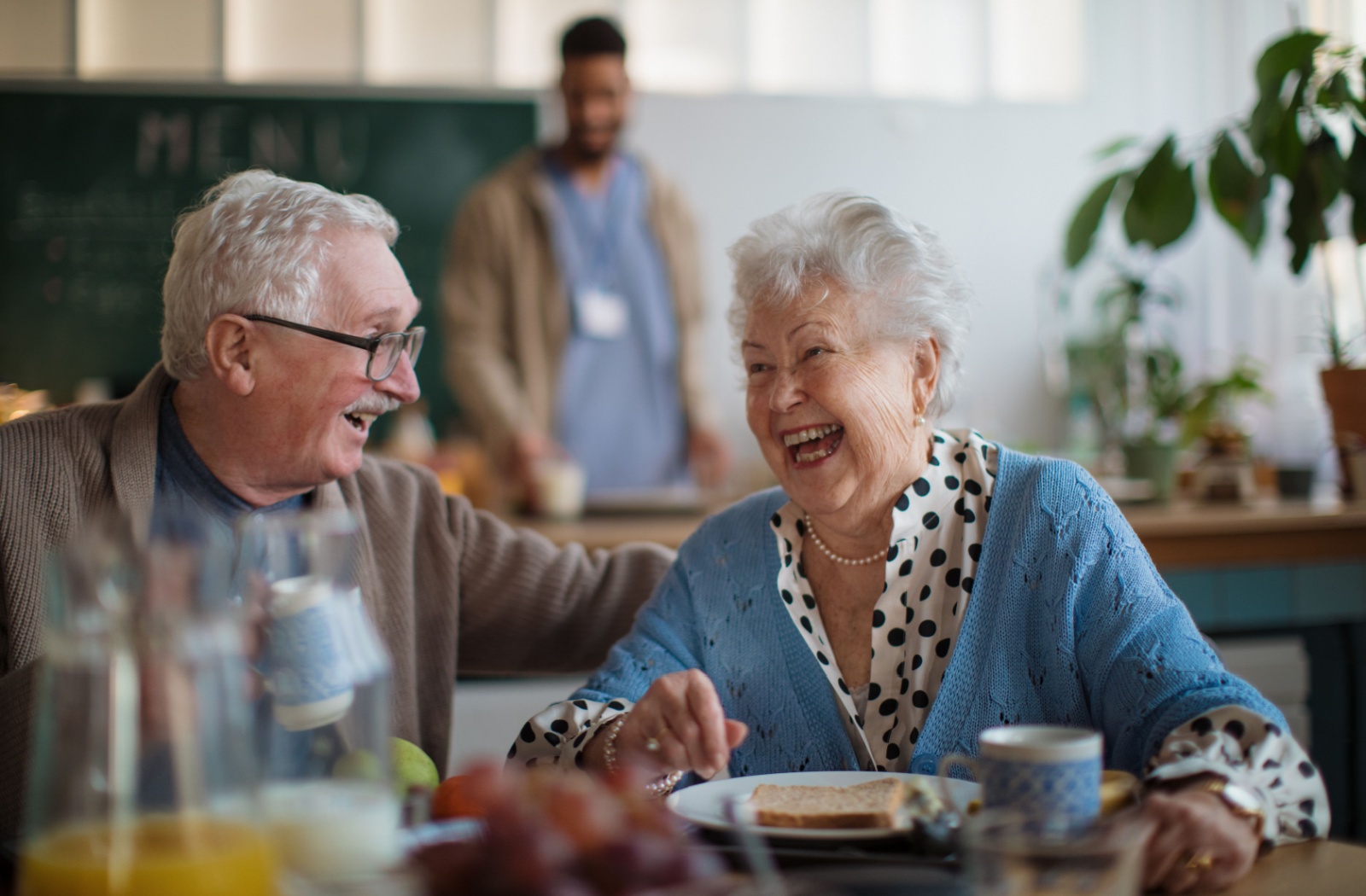A couple of happy seniors enjoy a meal together in a senior community.